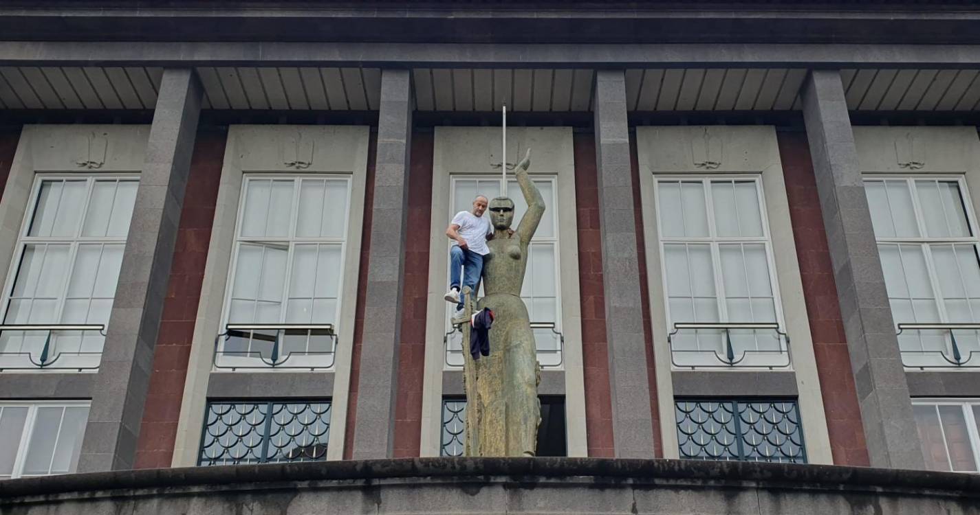 Homem coloca venda na estátua da justiça