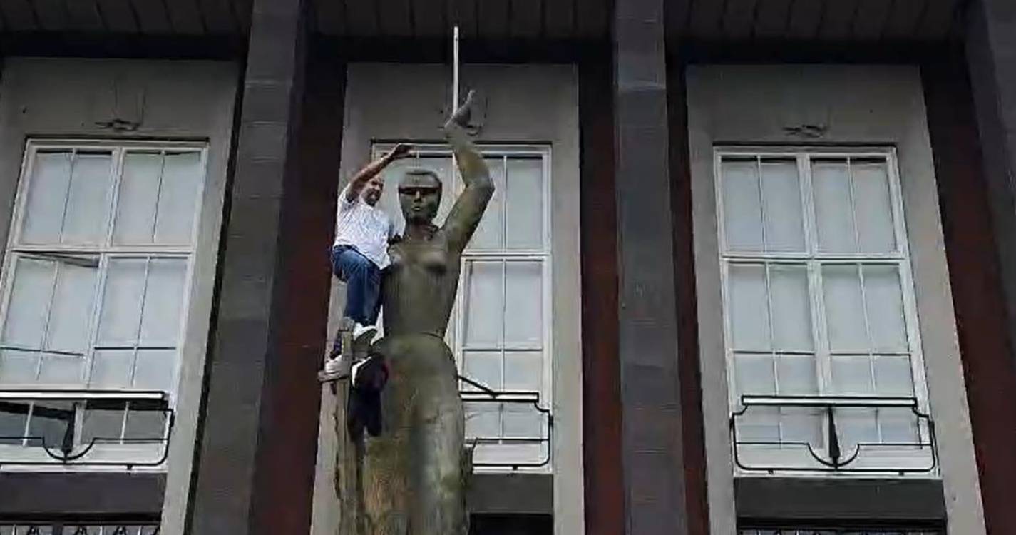 Homem coloca venda na estátua da justiça