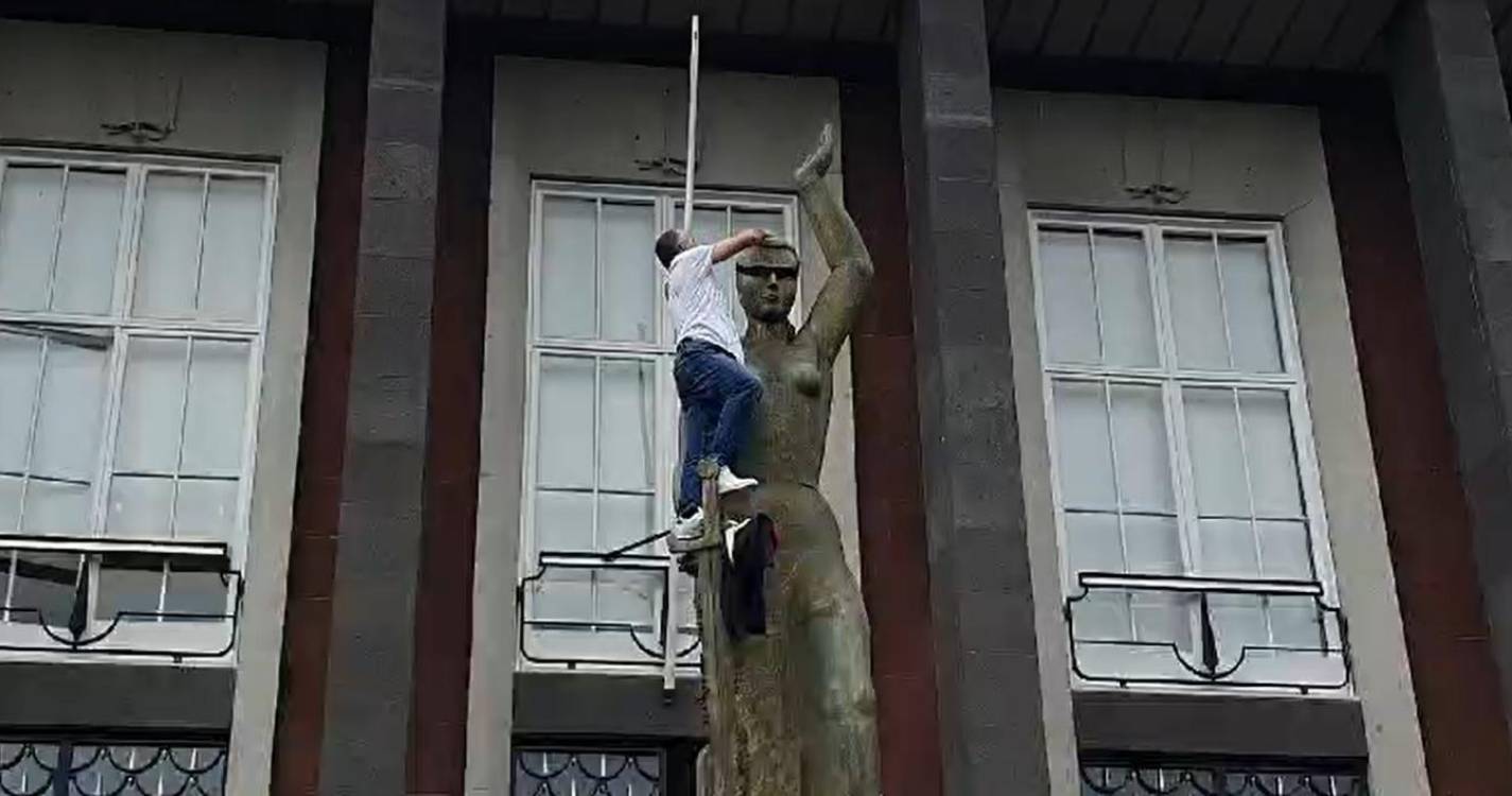 Homem coloca venda na estátua da justiça