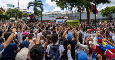 Cidadãos venezuelanos demonstram apoio a Edmundo González Urrutia durante campanha para as Eleições Presidenciais, em Caracas, a 30 de julho de 2024.