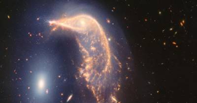 O observatório operado pela NASA e pela Agência Espacial Europeia fotografou as duas galáxias a 326 milhões de anos-luz de distância, rodeadas por uma névoa azul de estrelas e gás.