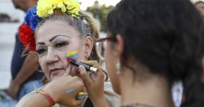 Manifestantes pintam bandeiras da Venezuela nas suas caras durante uma manifestação promovida por venezuelanos em Lisboa, 10 de agosto de 2024.