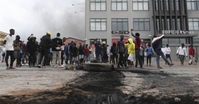 Manifestantes protestam junto a pneus queimados enquanto a polícia tenta dispersar as marcas pacíficas convocadas pelo candidato presidencial Venâncio Mondlane para repudiar o assassintado de dois apoiantes.