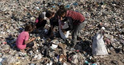 Crianças palestinianas recolhem lixo em Gaza.