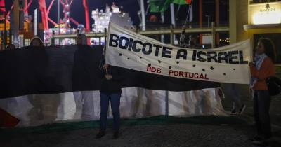 Manifestantes com bandeiras da Palestina protestaram à chegada do navio ao porto de Lisboa.