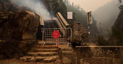 Parte do troço dos Passadiços do Paiva arde durante o incêndio que lavra no distrito de Aveiro, em Arouca.