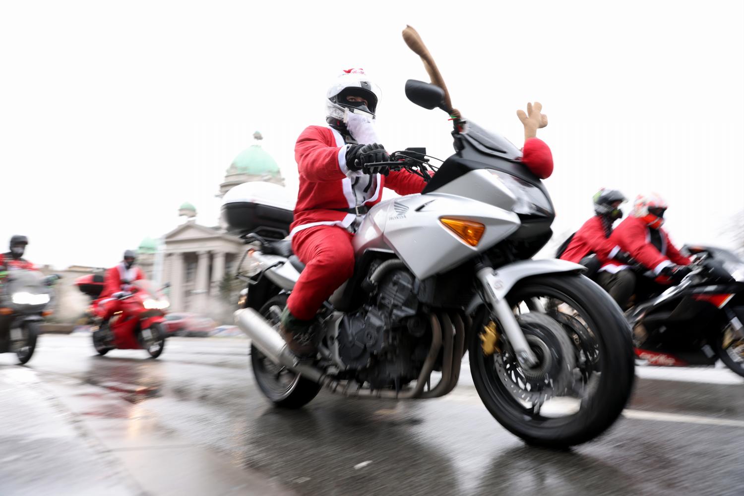 Motociclistas vestidos com fatos de Pai Natal levam presentes a crianças com deficiência (com fotos)