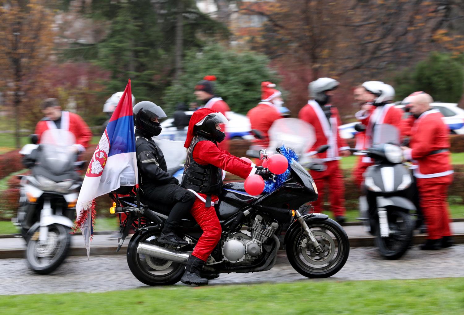 Motociclistas vestidos com fatos de Pai Natal levam presentes a crianças com deficiência (com fotos)