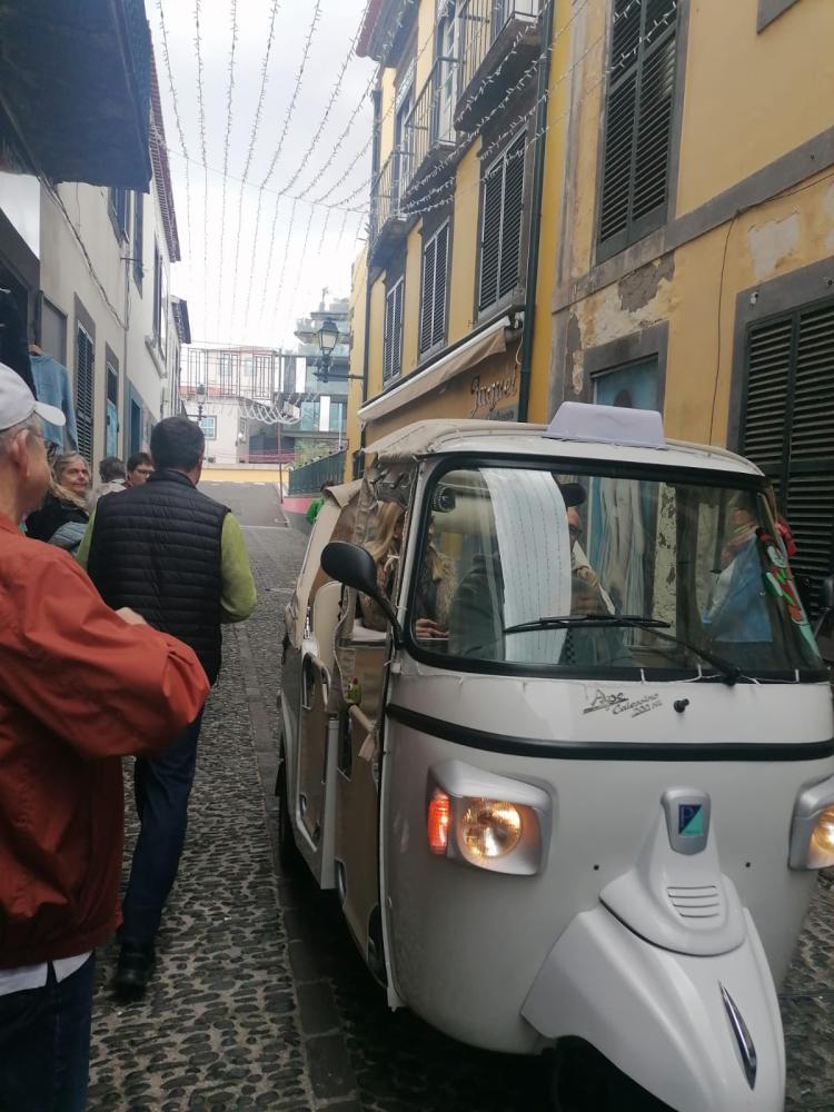 Peões passam muito perto da viatura em circulação.